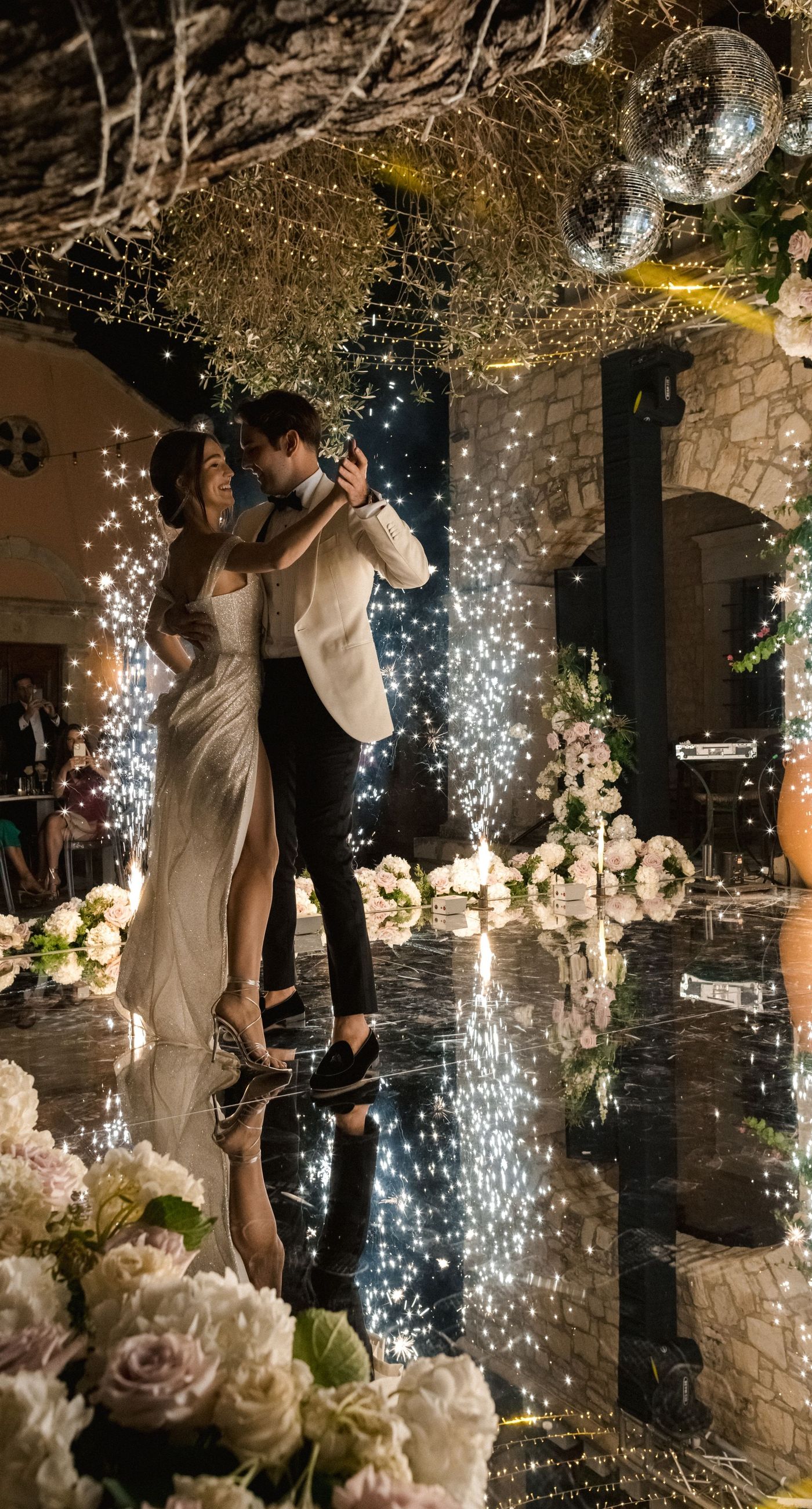  Sasha & Alex - Amidst a breathtaking landscape, this exquisite showcase captures the essence of romance and elegance. Soft hues of blush and ivory blend seamlessly with lush greenery, creating an ethereal garden-like setting. The mirrored aisle reflects the joyful union, adding a touch of glamor to the scene. Delicate florals, thoughtfully arranged, frame the moment, enhancing the dreamy, sophisticated atmosphere. This outdoor celebration perfectly balances natural beauty with refined artistry, embodying the timeless allure of love in a serene, picturesque locale. - Photo 9