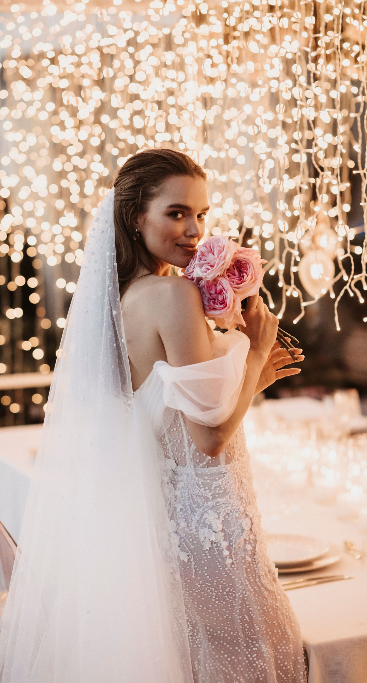 Agata & Paul - In a breathtaking celebration of love and nature's artistry, this exquisite floral masterpiece captures the essence of romance amidst a serene seaside backdrop. A delicate arch of blush pink and ivory blooms, interwoven with deep burgundy accents, frames the joyous moment, creating a harmonious blend of elegance and exuberance. The petals flutter like confetti through the air, adding a whimsical touch to the setting's charm. The terracotta and ivory-tiled floor provides a grounding contrast, enhancing the ethereal ambiance. It's a testament to the beauty that can be achieved when blossoms and emotions are artfully intertwined, making for a captivating introduction to a florist's portfolio. - Photo 1
