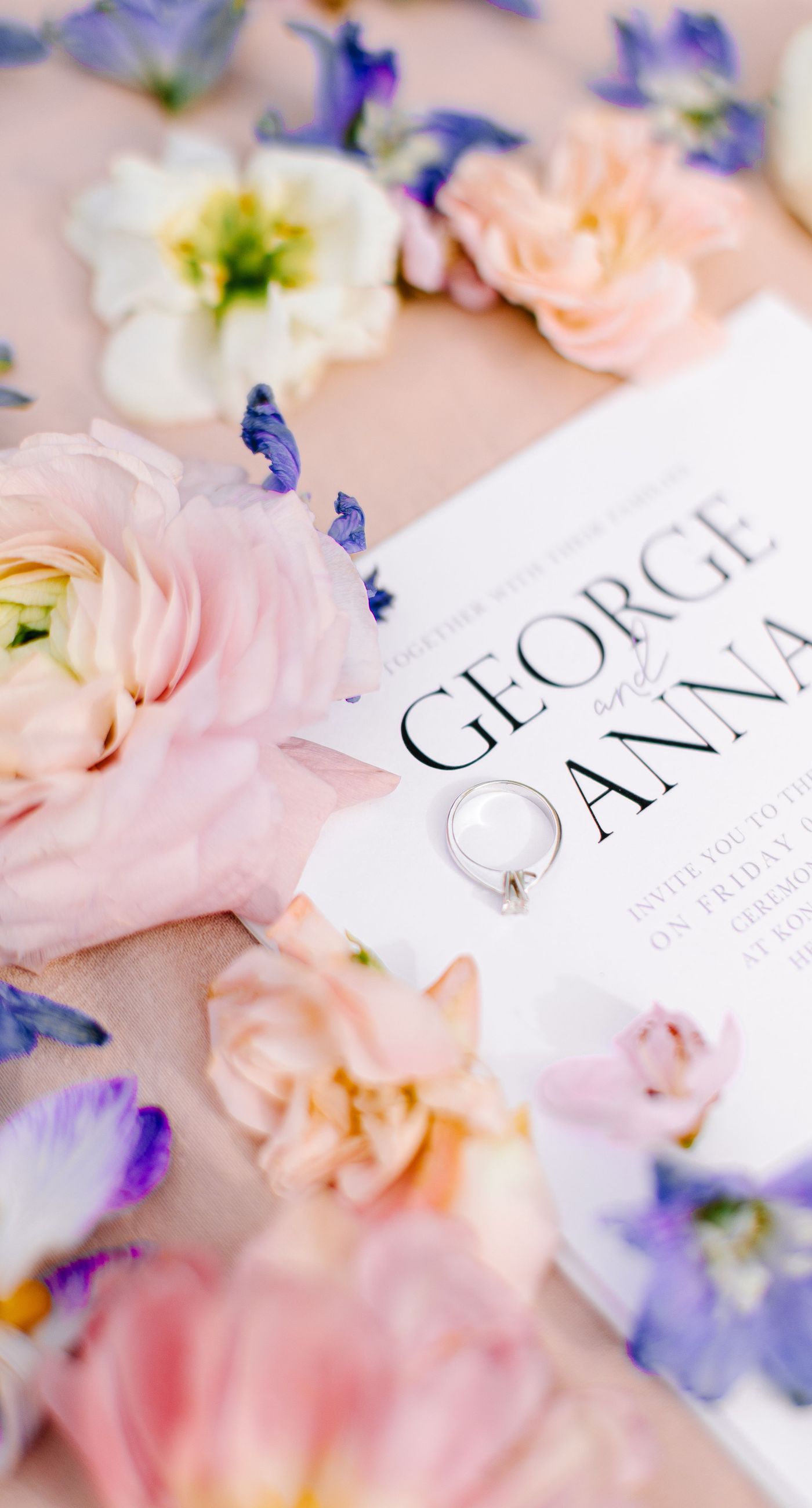 Alysia & Fraunk - Amidst the backdrop of a weathered, pale peach facade with antique windows, an enchanting scene unfolds. The romantic embrace of a couple is tenderly framed by a symphony of pastel-hued florals—soft pinks, gentle blues, and creamy whites—exuding timeless elegance. The delicate wild arrangements accentuate the ethereal beauty of the bridal dress, while the muted tones of the aged architecture blend seamlessly with the lush, garden-like display. This harmonious composition captures the essence of rustic romance, showcasing the florist's ability to weave nature's hues into a visual poem of love. - Photo 1