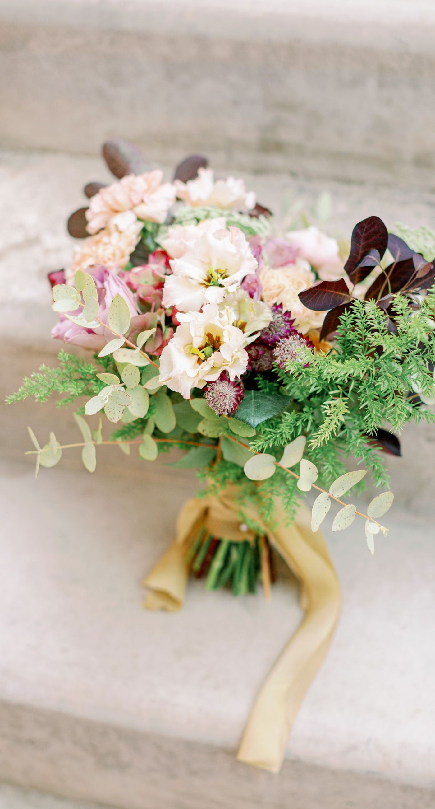 Chiara & Marco - In an elegant dance of romance and subtlety, a couple is enveloped in a moment of intimate anticipation. Their surroundings whisper of nature's abundance, while the soft, muted colors of the bouquet enhance the gentle harmony between the blue suit and white gown. The florist's artistry is evident in the meticulous arrangement of delicate blooms and verdant leaves, highlighting the signature flair for understated sophistication. This serene union of floral grace and human connection brings forth an aesthetic that is both timeless and heartwarming, ideal for a setting that celebrates love and nature in its simplest form. - Photo 7