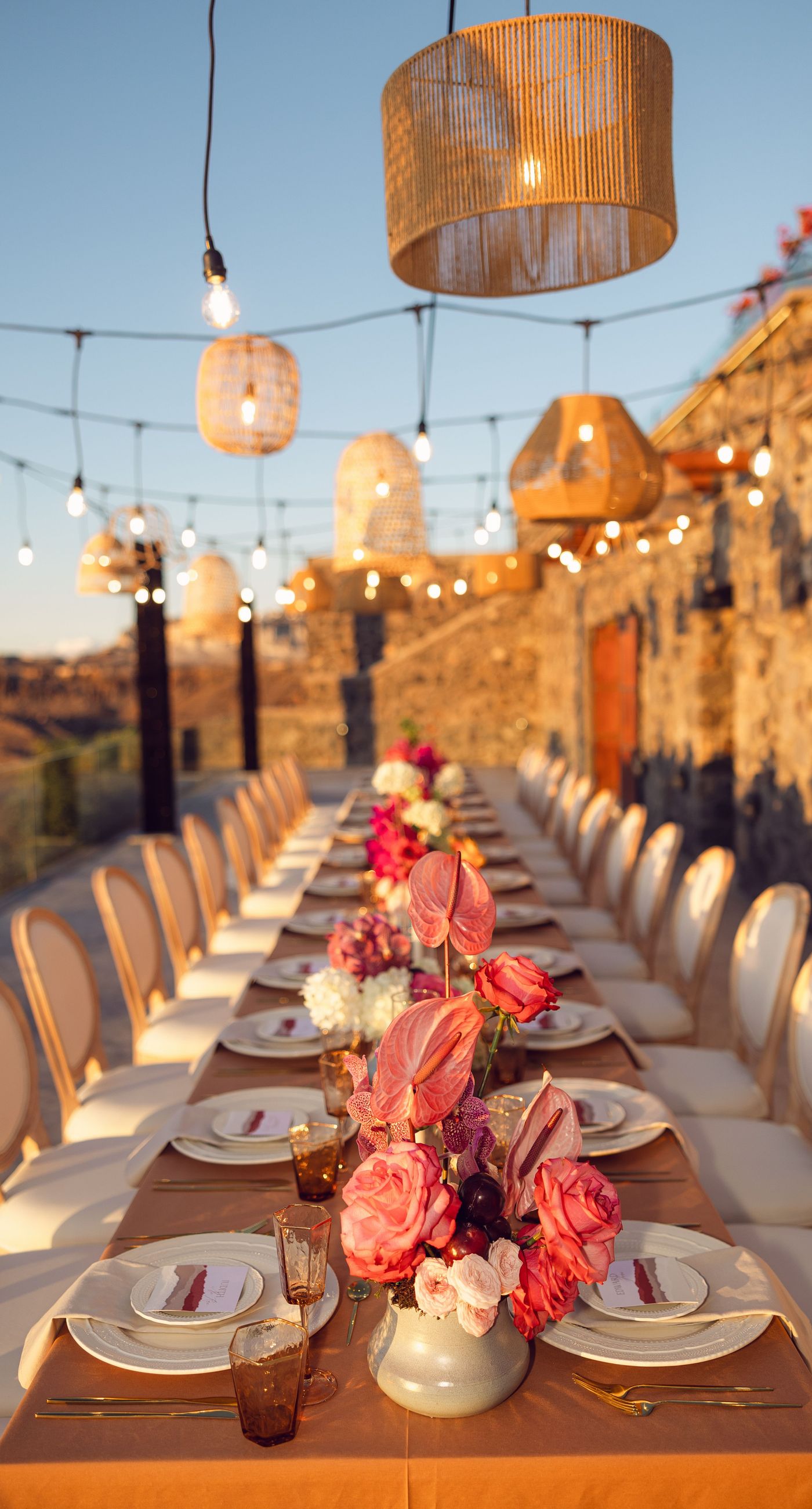 Chris & Jazmin - In a dreamlike setting beneath the soft embrace of the sun, this captivating work embodies a perfect union of elegance and romance. The delicate lace of her gown interlaces with the tender embrace of her partner, creating an ethereal atmosphere amidst the tranquil architecture. A vibrant bouquet bursts with life, featuring an exquisite medley of fuchsia, orange, and deep crimson blooms, each petal whispering tales of timeless love. The muted tones of the setting contrast beautifully with the vivid flowers, offering a glimpse into a serene world where artistry and nature harmonize flawlessly. This presentation speaks to the profound beauty that can blossom in moments of connection. - Photo 8