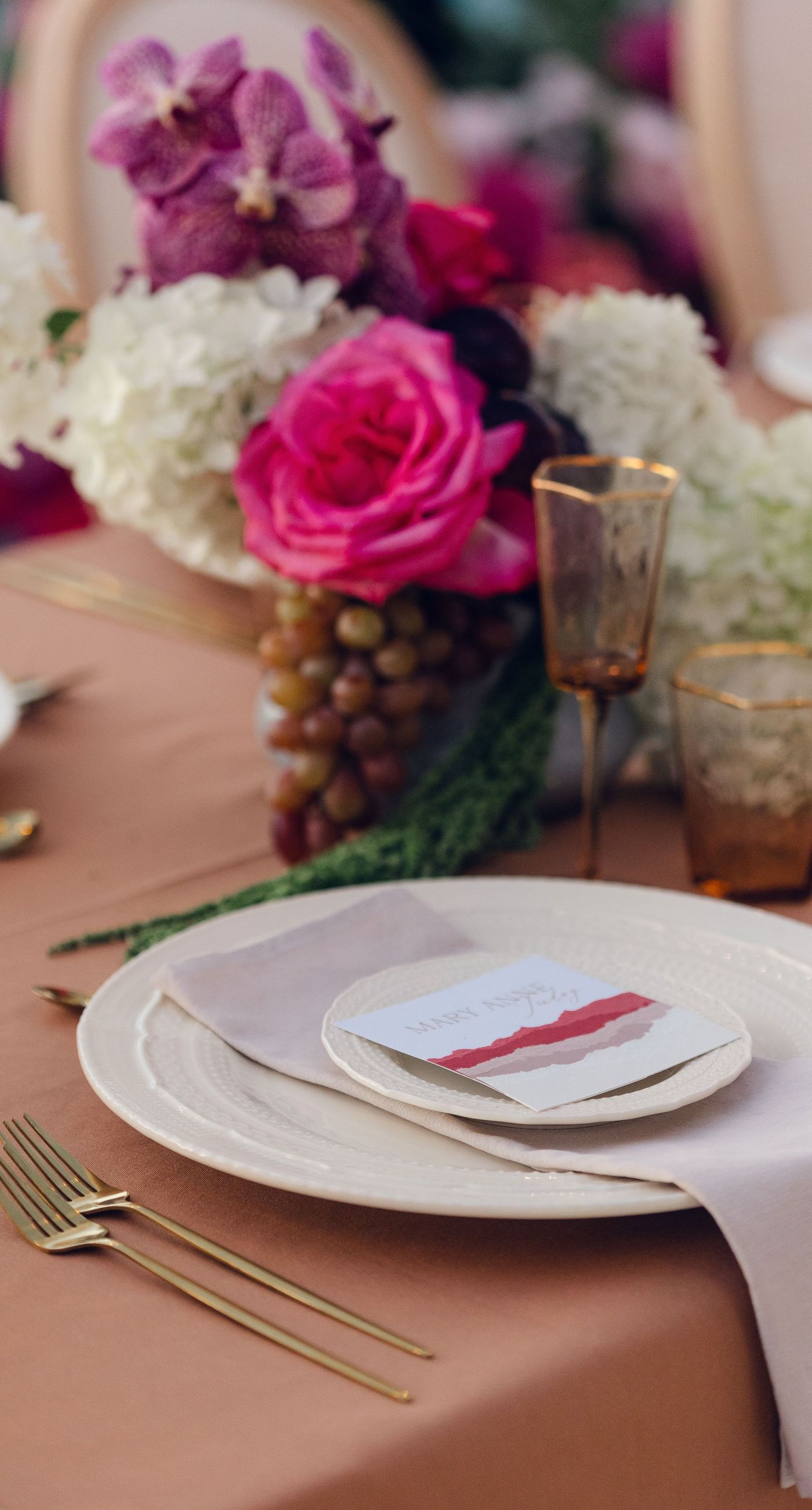 Chris & Jazmin - In a dreamlike setting beneath the soft embrace of the sun, this captivating work embodies a perfect union of elegance and romance. The delicate lace of her gown interlaces with the tender embrace of her partner, creating an ethereal atmosphere amidst the tranquil architecture. A vibrant bouquet bursts with life, featuring an exquisite medley of fuchsia, orange, and deep crimson blooms, each petal whispering tales of timeless love. The muted tones of the setting contrast beautifully with the vivid flowers, offering a glimpse into a serene world where artistry and nature harmonize flawlessly. This presentation speaks to the profound beauty that can blossom in moments of connection. - Photo 12