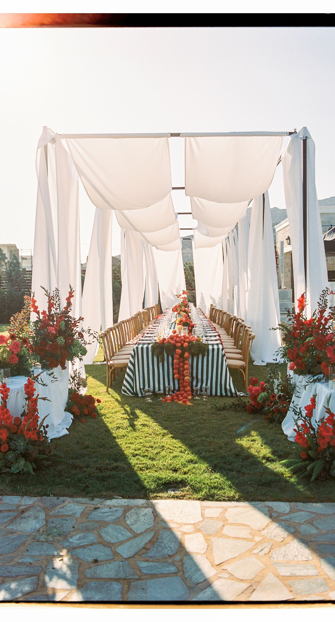 Garden Ceremony - A complete wedding experience designed with a focus on color, flow, and a strong sense of place. The ceremony is framed by vibrant florals in warm tones, creating a natural and expressive setting for the couple. The dinner that follows is defined by long tables, rhythmic textiles, and unexpected details that introduce a sense of playful elegance. A project that balances structure and ease, designed to feel authentic and experienced without effort. - Photo 7