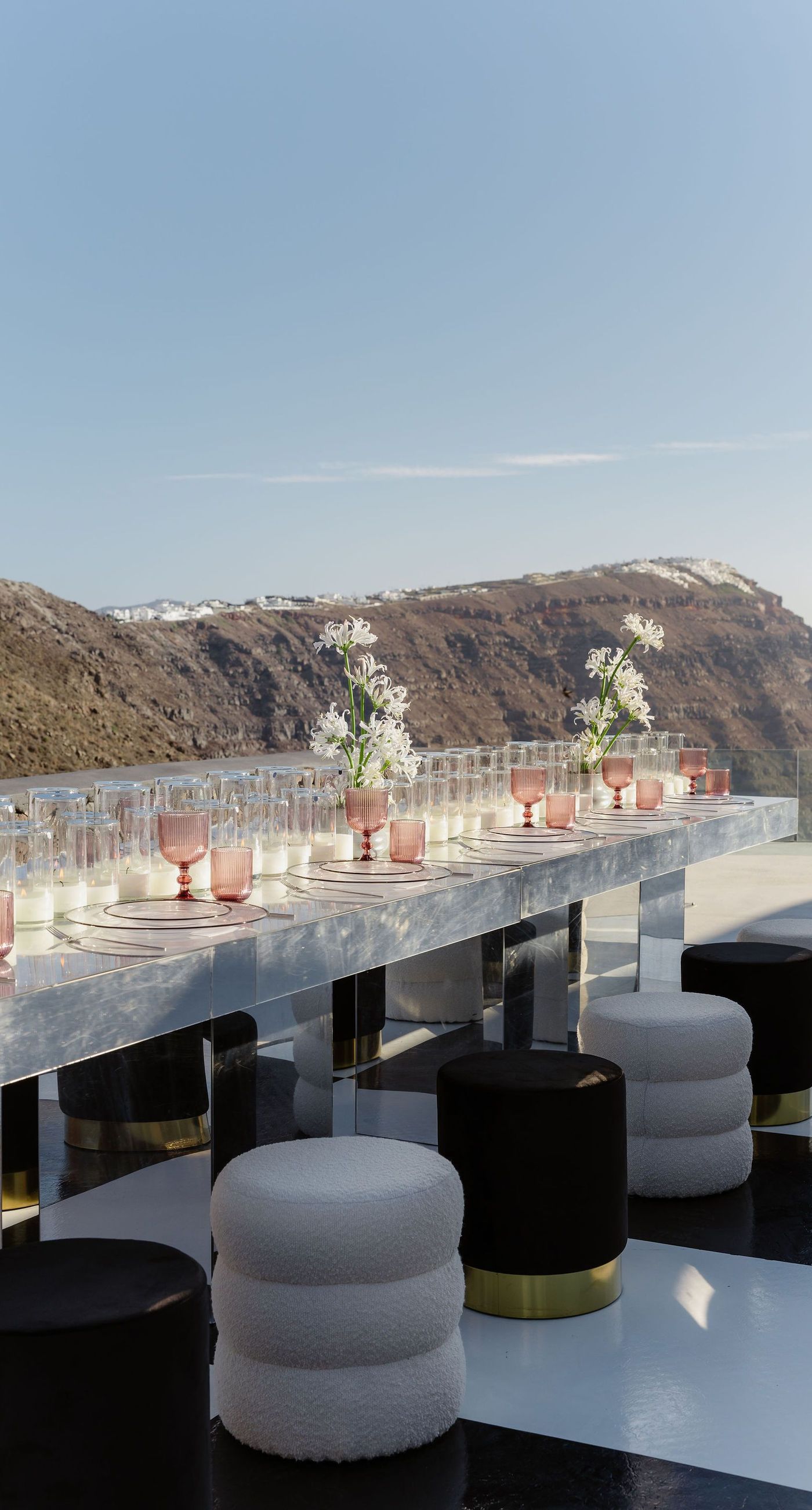 Emily & liam - In this exquisite scene, a couple stands in an ethereal embrace on a glass platform, surrounded by delicate blossoms that mirror the elegance of a sunlit seascape. The subdued pastels of the sunset wash gently over the horizon, casting a serene glow upon the couple and the blooms, creating a harmonious symphony of colors and emotions. The gracefully arranged white flowers echo timeless beauty and sophistication, set against the tranquil backdrop of a distant island. This stunning tableau invites you into a world where nature and romance converge seamlessly, an ideal representation for any florist's portfolio that values artistry and grace. - Photo 6
