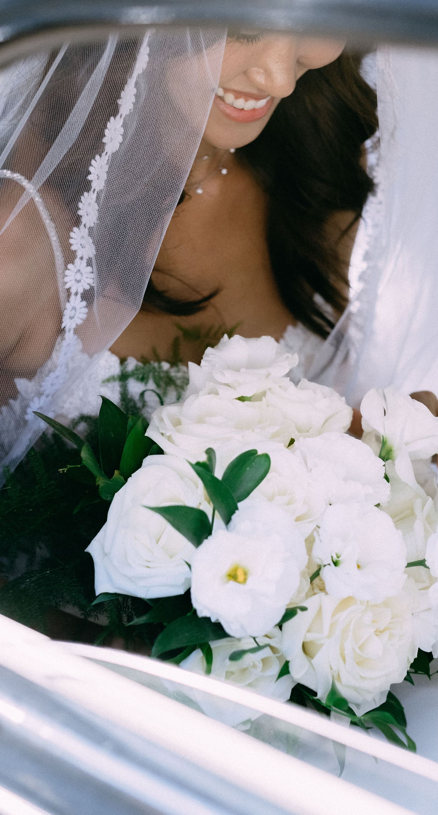 June & Tim - Beneath a lush canopy of greenery, a symphony of ivory and blush blooms cascades in a breathtaking floral arch. The delicate roses and verdant ferns intertwine effortlessly, creating a harmonious backdrop that exudes elegance and romance. The serene garden setting bathes the scene in soft, natural light, enhancing the ethereal beauty of the arrangement. The joyful expressions of the couple, captured in this radiant moment, complement the stunning florals with a vibrant energy. This captivating work reflects a masterful blend of nature's artistry and human emotion, making it an unforgettable statement in any portfolio. - Photo 4