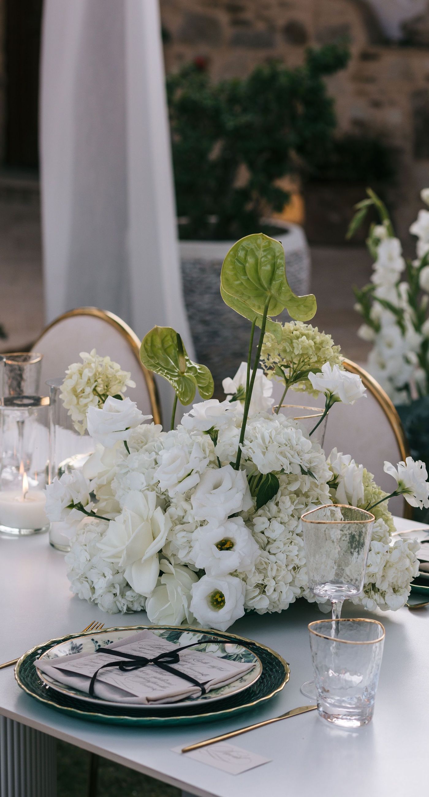 Kala & Kerwin - Bathed in the warm glow of a setting sun, the bouquet of creamy white blooms and eucalyptus whispers elegance and romance. It complements the ethereal lace details of the attire, creating a harmonious blend of textures and colors. The backdrop of rustic stone steps hints at a location where nature and romance intertwine seamlessly, offering a timeless, serene beauty. This work encapsulates a moment of profound connection and grace, emphasizing the pure emotional essence captured on a special day. - Photo 6