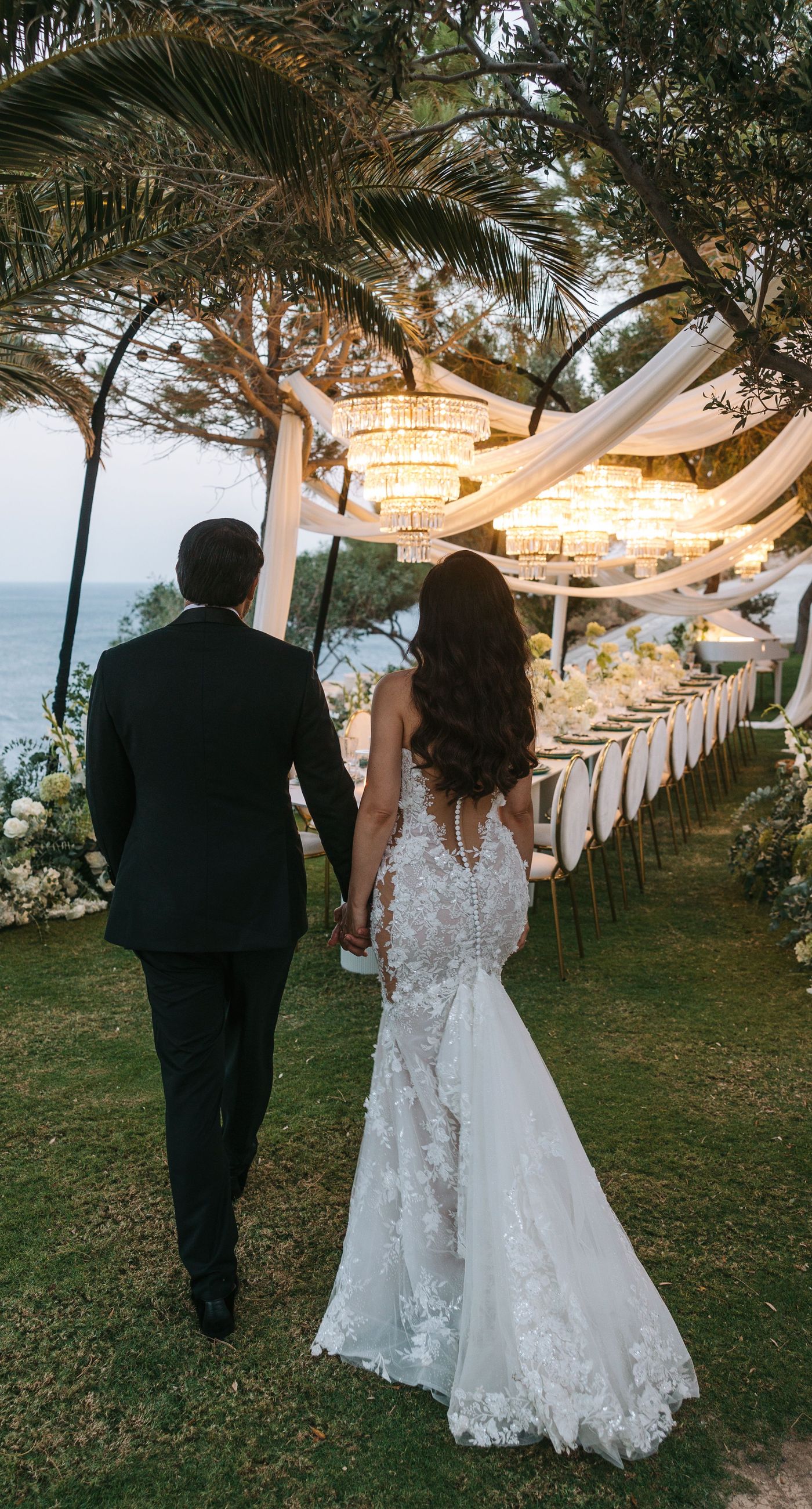 Kala & Kerwin - Bathed in the warm glow of a setting sun, the bouquet of creamy white blooms and eucalyptus whispers elegance and romance. It complements the ethereal lace details of the attire, creating a harmonious blend of textures and colors. The backdrop of rustic stone steps hints at a location where nature and romance intertwine seamlessly, offering a timeless, serene beauty. This work encapsulates a moment of profound connection and grace, emphasizing the pure emotional essence captured on a special day. - Photo 3