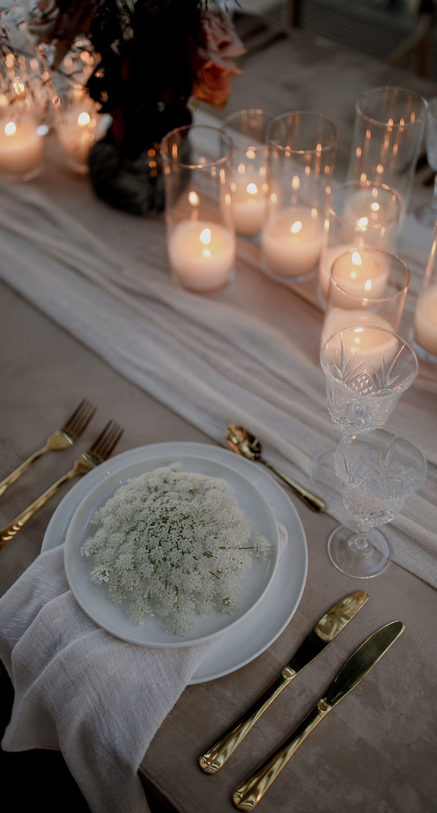 Monika & Ryan - Under a gentle sky that meets a serene coastline, a beautifully crafted floral arch frames an intimate moment of joy and elegance. Soft blush roses and pristine white orchids cascade amid deep burgundy leaves, creating a lush tapestry that echoes the surrounding natural beauty. The harmonious blend of textures and muted colors evokes a sense of timeless romance, making each element of the design feel both organic and artful. The scene captures the essence of a tranquil seaside celebration, where nature's breathtaking backdrop complements the exquisite floral artistry. - Photo 5