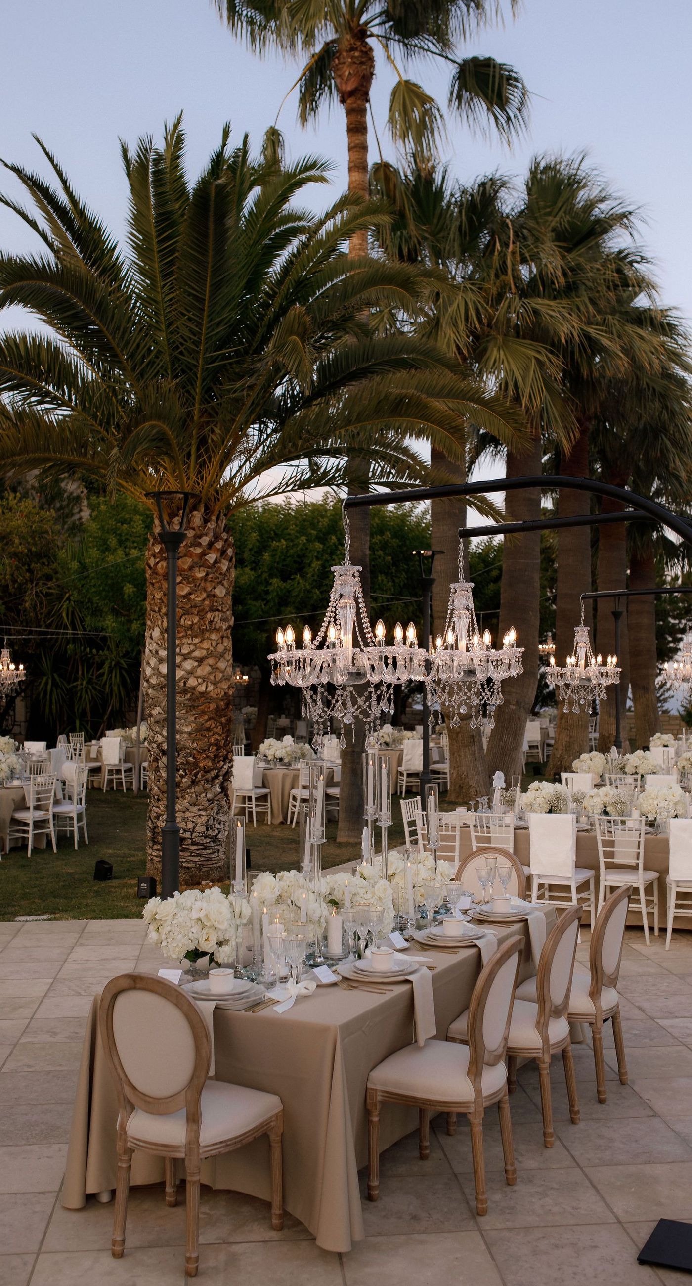 Natalia & John  - Amidst a cascade of ivory roses and lush greenery, an elegantly composed scene unfolds, embodying a timeless romance. The bride, draped in a voluminous white gown, holds a delicate bouquet of blooms that mirrors the floral splendor surrounding her. The groom, in classic black tie, complements the serene palette with a touch of timeless elegance. This artistic composition brings together the soft whispers of petals and the gentle embrace of forgotten days, creating a vibrant harmony between nature's charm and heartfelt human moments. The florals, artfully arranged, create an enchanting backdrop that speaks of new beginnings and enduring beauty. - Photo 11