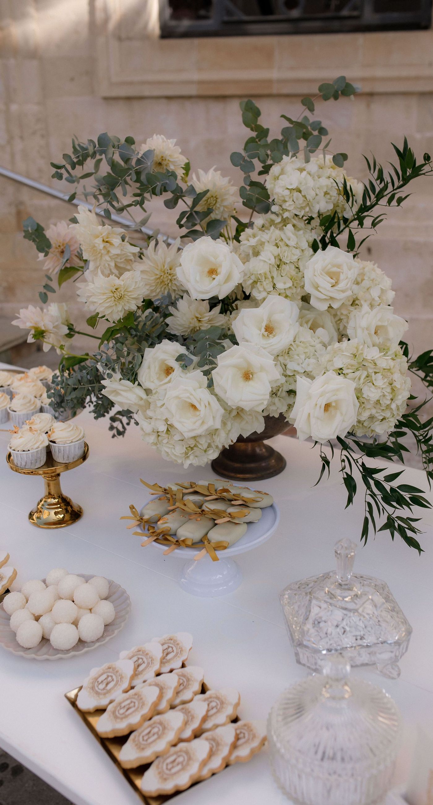 Natalia & John  - Amidst a cascade of ivory roses and lush greenery, an elegantly composed scene unfolds, embodying a timeless romance. The bride, draped in a voluminous white gown, holds a delicate bouquet of blooms that mirrors the floral splendor surrounding her. The groom, in classic black tie, complements the serene palette with a touch of timeless elegance. This artistic composition brings together the soft whispers of petals and the gentle embrace of forgotten days, creating a vibrant harmony between nature's charm and heartfelt human moments. The florals, artfully arranged, create an enchanting backdrop that speaks of new beginnings and enduring beauty. - Photo 5