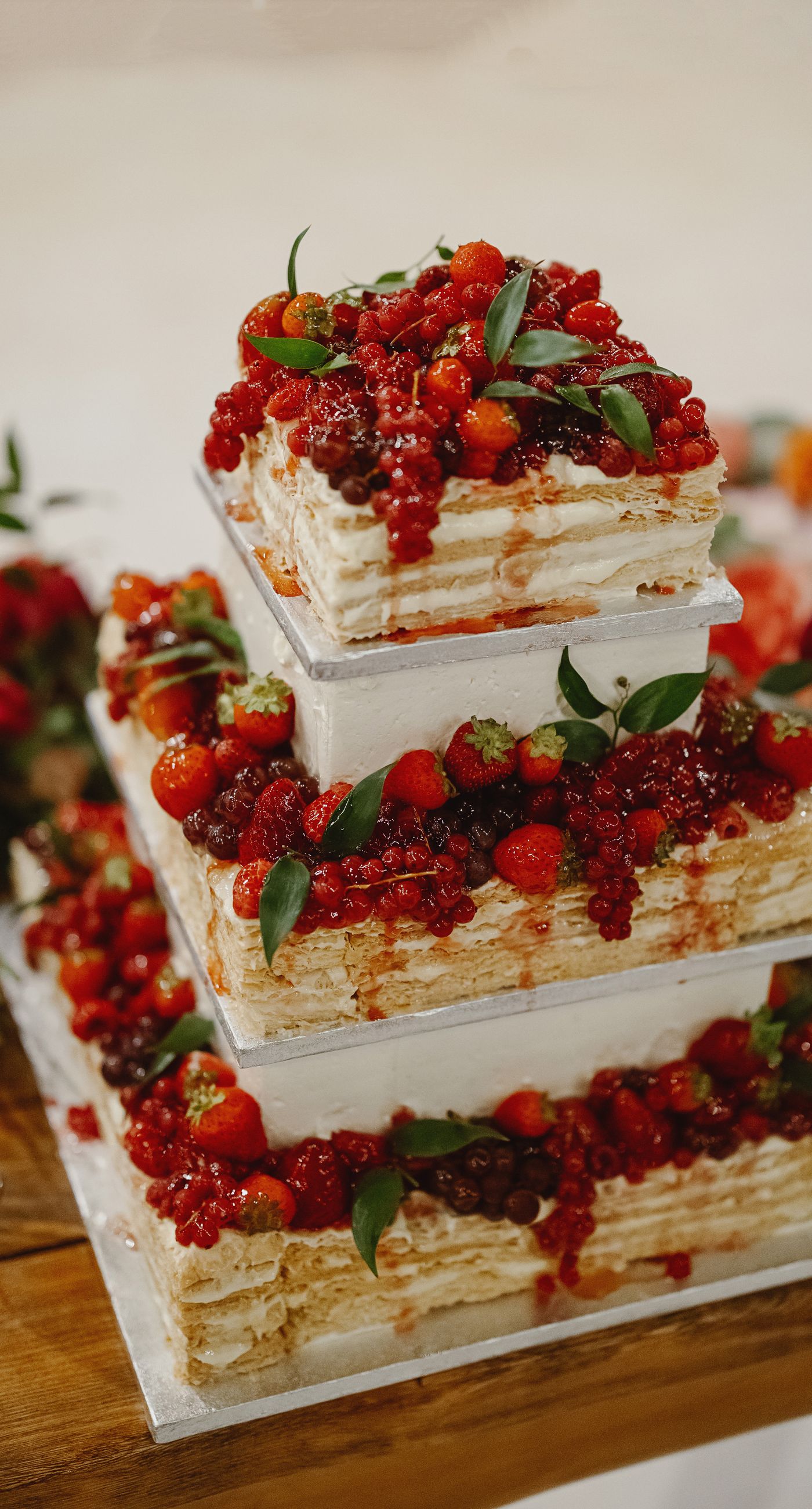 Where Celebration Meets Nature - A modern garden wedding with clean lines and a strong sense of a curated dining experience.
Long communal tables set within the vineyard, statement floral arrangements at varying heights, layers of greenery with bold color accents, and warm lighting that carried the atmosphere from day into night. A setting that felt natural yet intentionally designed  contemporary, vibrant, and effortlessly elegant. - Photo 13