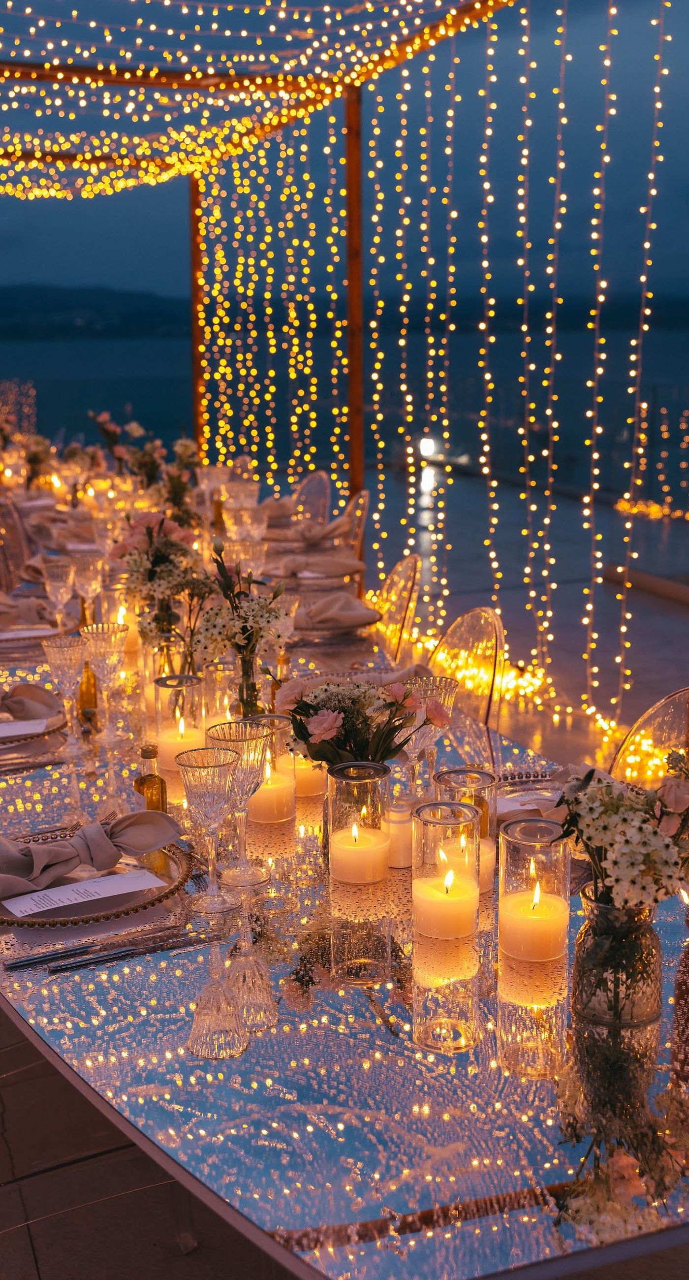 Shay & Vedad - In the serene elegance of a Greek wedding, a mirrored sign stands as a testament to love and artistry. The names "Shay and Vedad" are embossed in sleek white typography, reflecting a moment of intimate celebration bathed in soft, natural light. The minimalist, contemporary aesthetic is accented by subtle greenery, evoking a sense of tranquility and romance amidst the timeless beauty of Crete. The composition captures the harmonious blend of modern elegance with organic details, drawing you into a world where love and nature seamlessly intertwine. - Photo 7