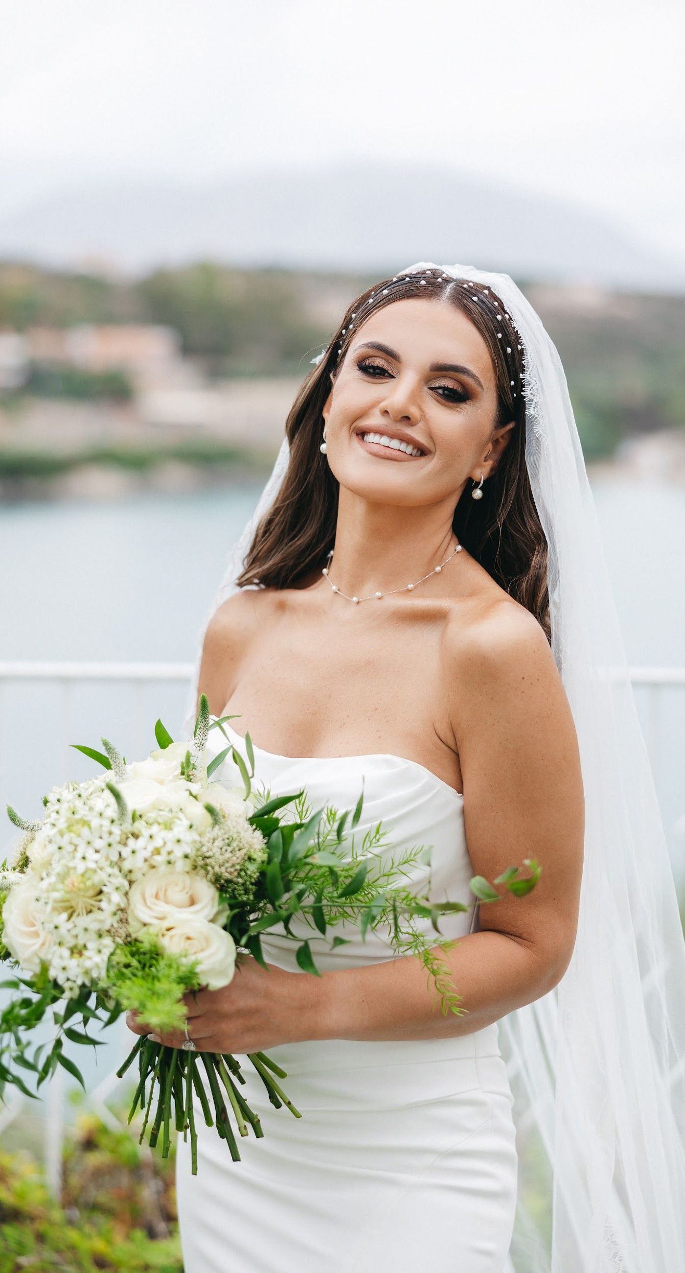 Shay & Vedad - In the serene elegance of a Greek wedding, a mirrored sign stands as a testament to love and artistry. The names "Shay and Vedad" are embossed in sleek white typography, reflecting a moment of intimate celebration bathed in soft, natural light. The minimalist, contemporary aesthetic is accented by subtle greenery, evoking a sense of tranquility and romance amidst the timeless beauty of Crete. The composition captures the harmonious blend of modern elegance with organic details, drawing you into a world where love and nature seamlessly intertwine. - Photo 3