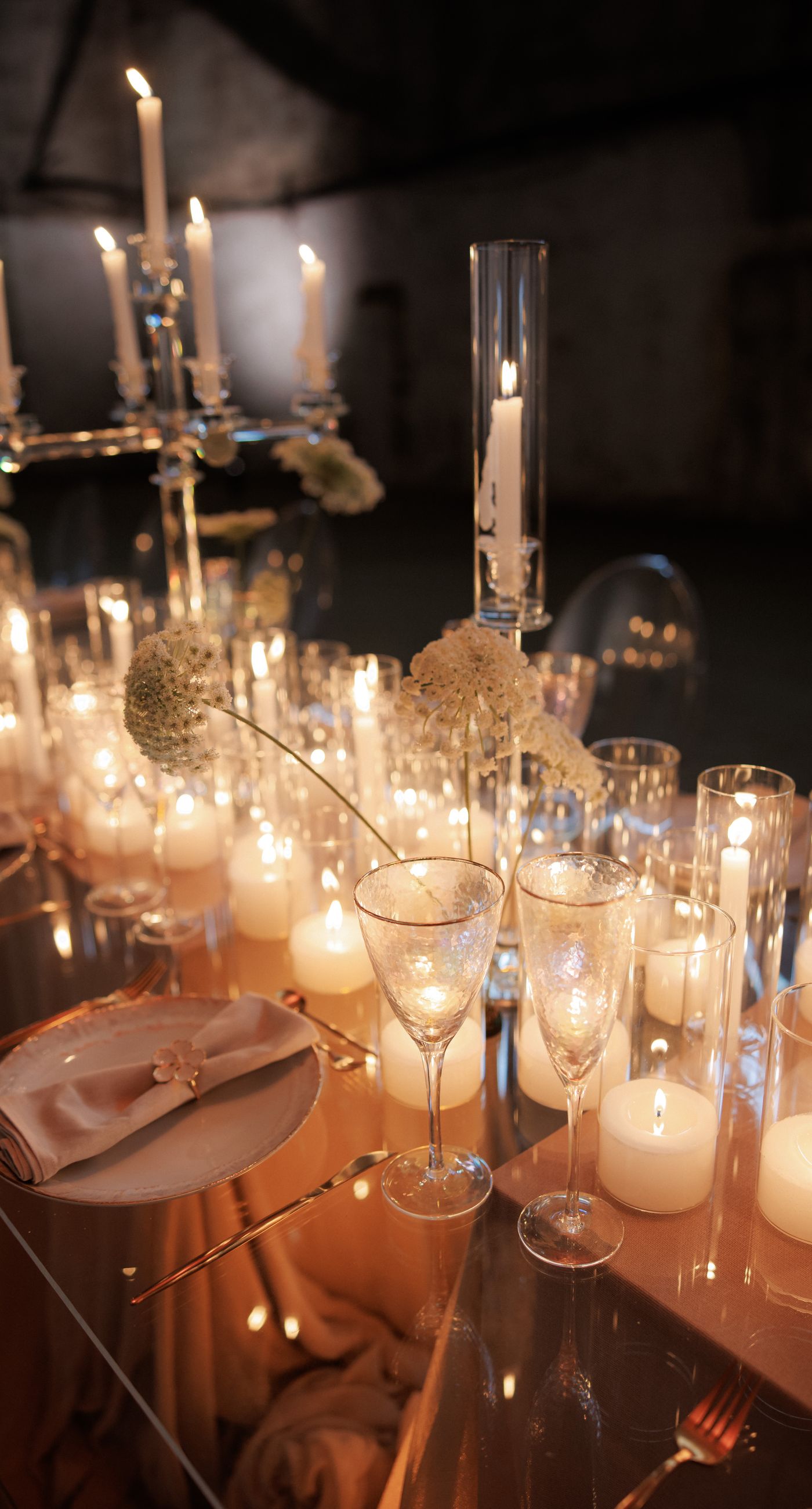 The Extravaganza Flower - Set within an industrial space, this project was conceived as an atmospheric dining experience where light and form take center stage. A sculptural, suspended installation “blooms” above the table, creating depth and scenography, while a candlelit setup adds warmth and intimacy. Clean lines, transparent materials, and subtle florals complete a design that goes beyond decoration it is installation art with emotion. - Photo 6