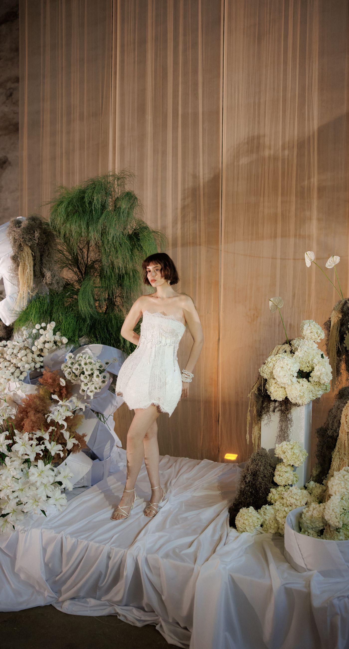 The Extravaganza Flower - Set within an industrial space, this project was conceived as an atmospheric dining experience where light and form take center stage. A sculptural, suspended installation “blooms” above the table, creating depth and scenography, while a candlelit setup adds warmth and intimacy. Clean lines, transparent materials, and subtle florals complete a design that goes beyond decoration it is installation art with emotion. - Photo 4