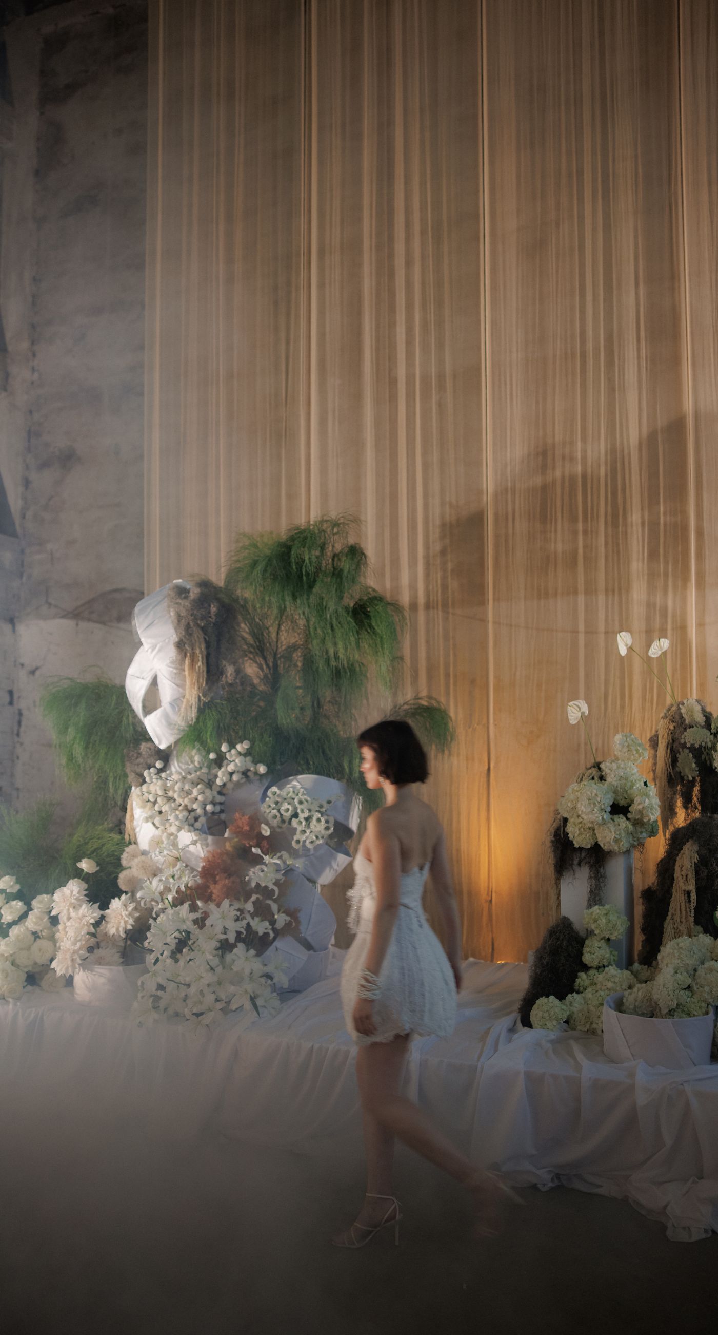 The Extravaganza Flower - Set within an industrial space, this project was conceived as an atmospheric dining experience where light and form take center stage. A sculptural, suspended installation “blooms” above the table, creating depth and scenography, while a candlelit setup adds warmth and intimacy. Clean lines, transparent materials, and subtle florals complete a design that goes beyond decoration it is installation art with emotion. - Photo 2