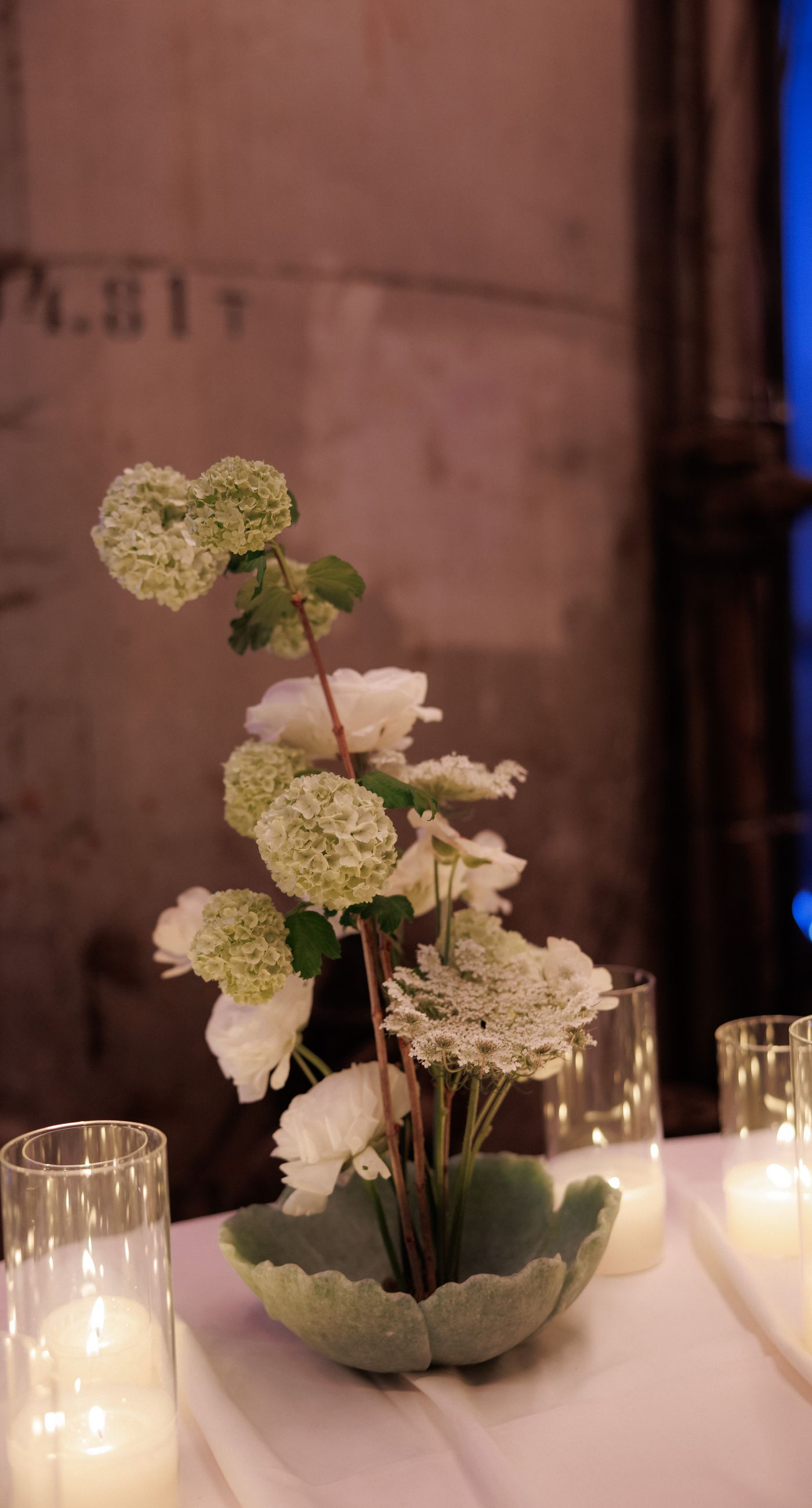 In the Glow - We designed an atmospheric candlelit dining setup that blends modern aesthetics with romantic warmth. Glass candle holders, layered candlelight, and elegant floral arrangements in soft tones create a refined experience for guests, ideal for editorial weddings and contemporary events. A setting that enhances the space and transforms dinner into a memorable moment - Photo 7